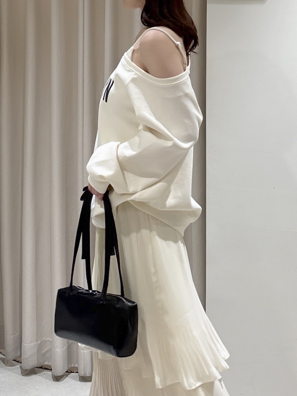 ホワイト系のスウェット、ホワイト系のスカート、ブラック系のショルダーバッグを着用したレディースの春コーディネートの4枚目の写真