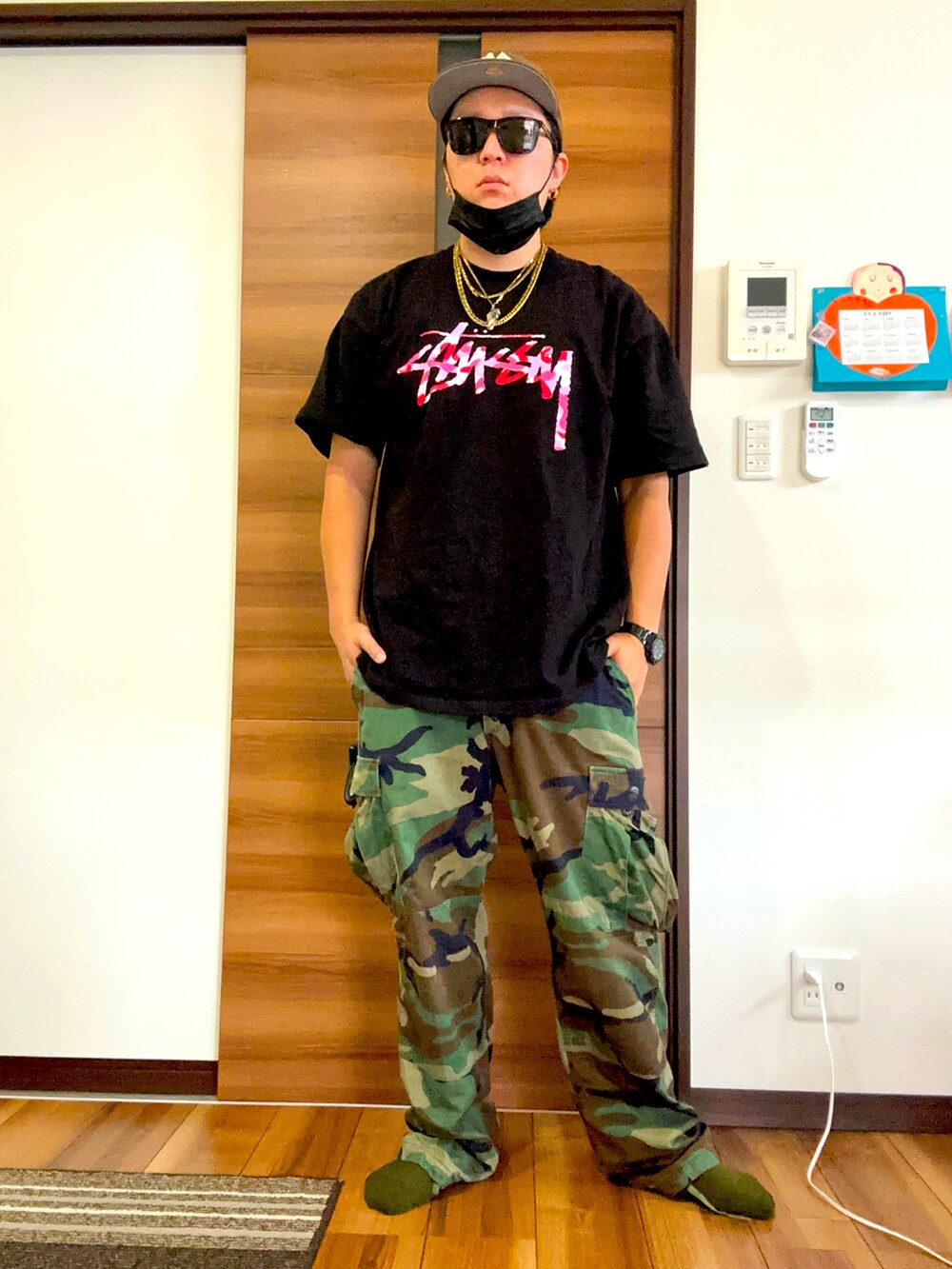 ブラック系のTシャツ/カットソー、グリーン系のカーゴパンツを着用したメンズの夏コーディネートの2枚目の写真