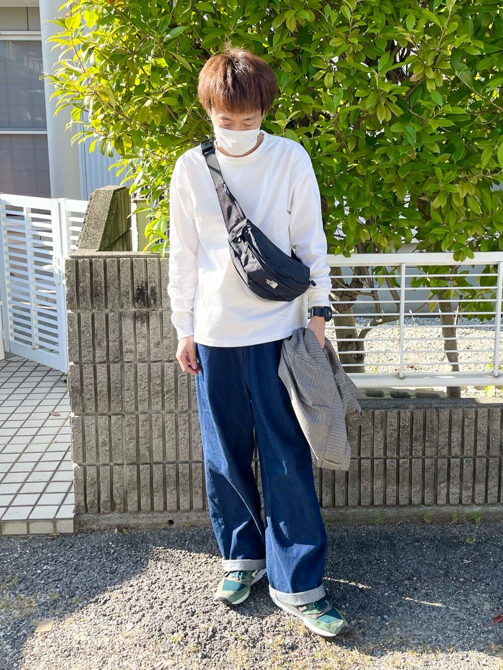 ホワイト系のTシャツ/カットソー、ブルー系のデニムパンツを着用したメンズの秋コーディネートの2枚目の写真