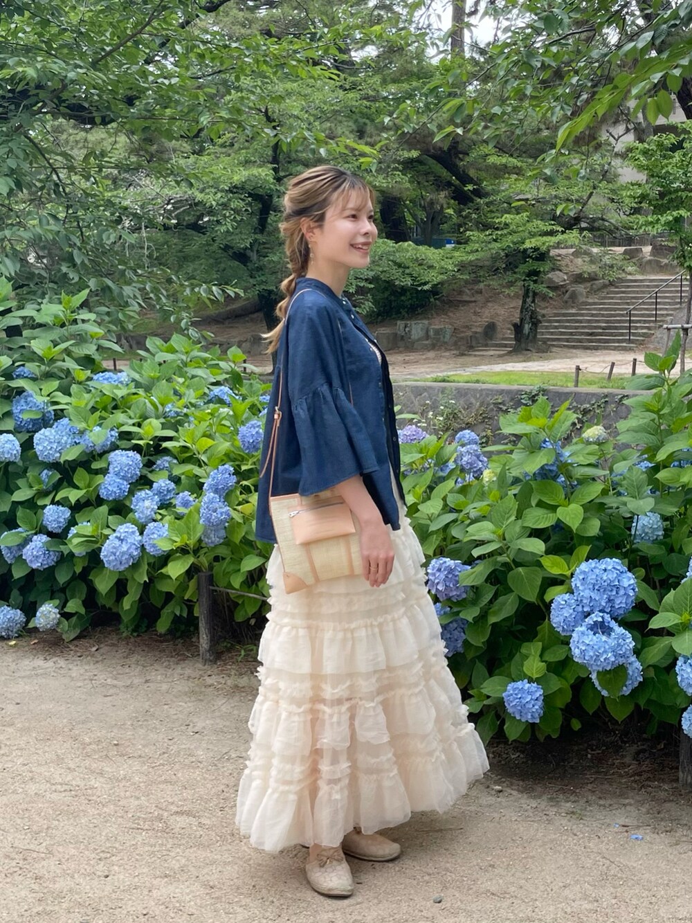 ブルー系のシャツ/ブラウス、ブラウン系のタンクトップ、ベージュ系のショルダーバッグを着用したレディースの夏コーディネートの3枚目の写真