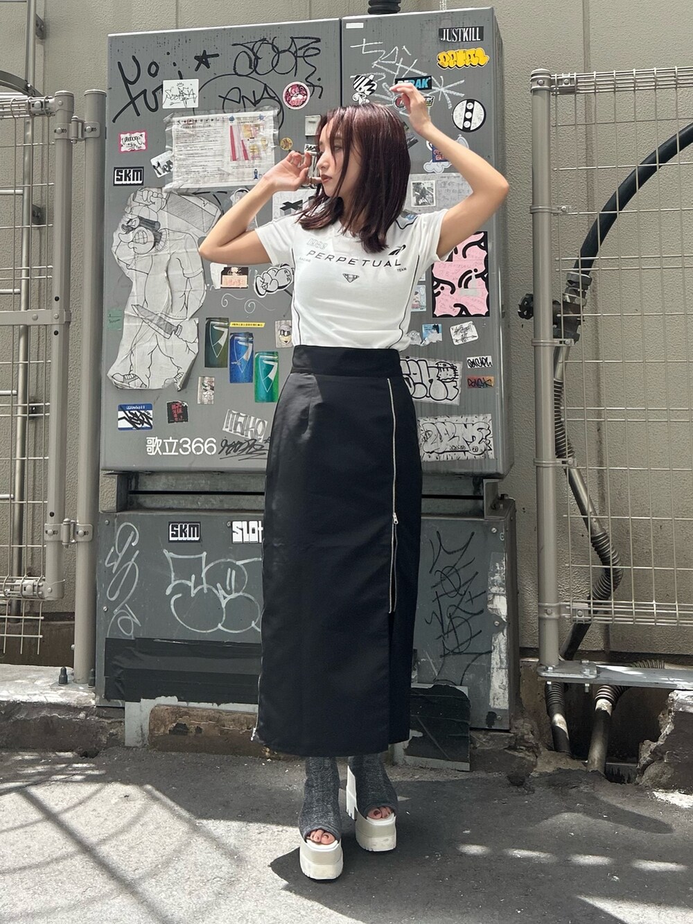 シルバー系のブーツ、ブラック系のスカート、ホワイト系のTシャツ/カットソーを着用したレディースの夏コーディネートの2枚目の写真