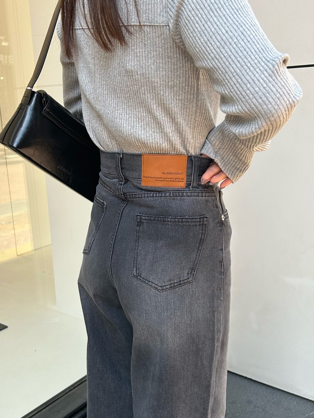 グレー系のTシャツ/カットソー、ブラック系のデニムパンツ、ブラック系のショルダーバッグを着用したレディースの春コーディネートの4枚目の写真