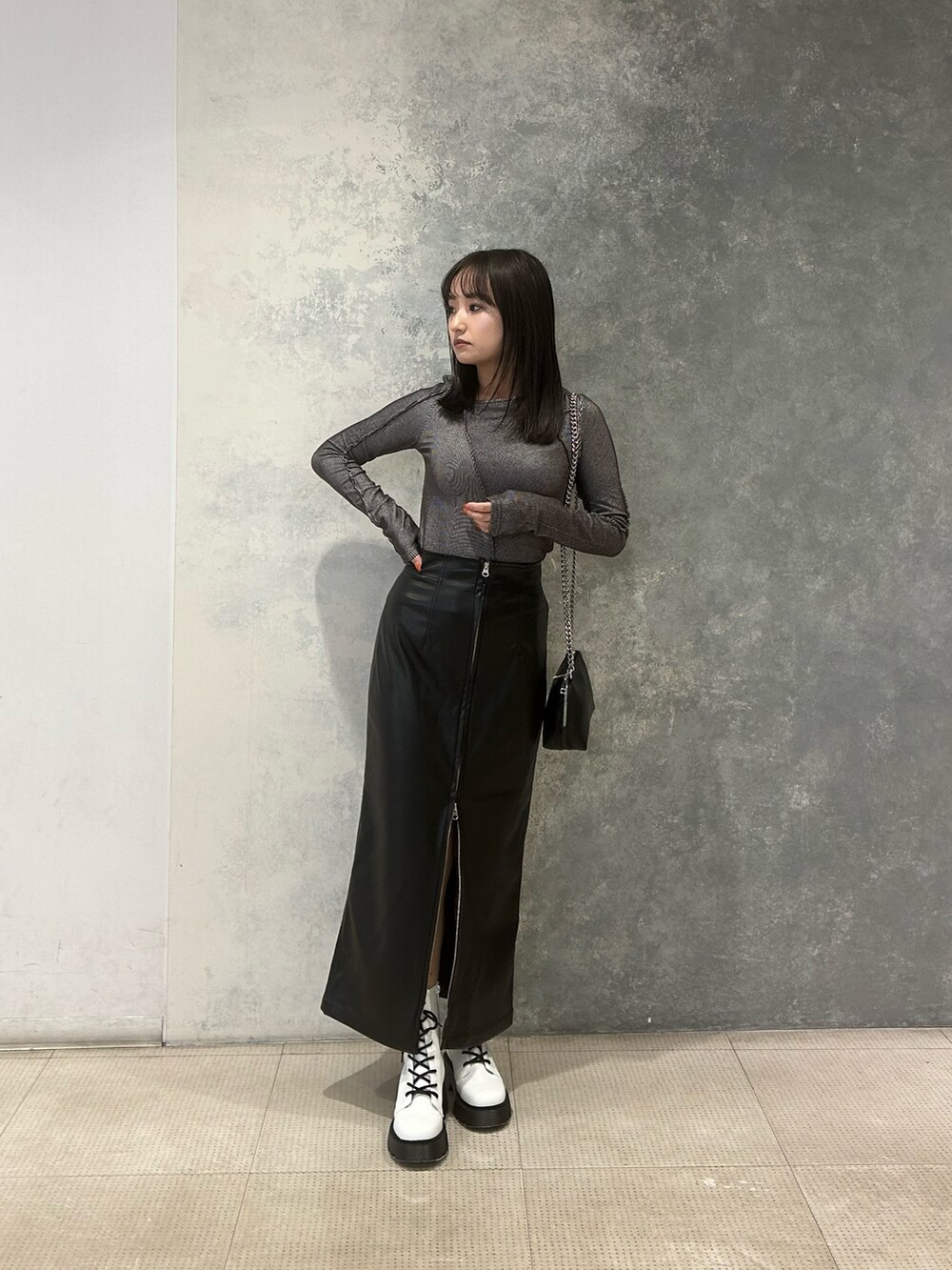 グレー系のTシャツ/カットソー、ブラック系のスカート、ブラック系のハンドバッグを着用したレディースの冬コーディネートの2枚目の写真