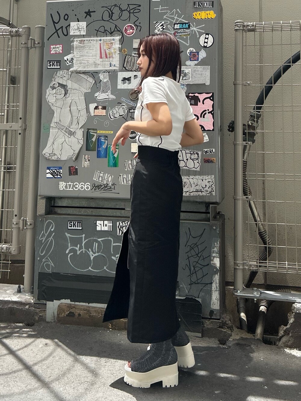 シルバー系のブーツ、ブラック系のスカート、ホワイト系のTシャツ/カットソーを着用したレディースの夏コーディネートの4枚目の写真