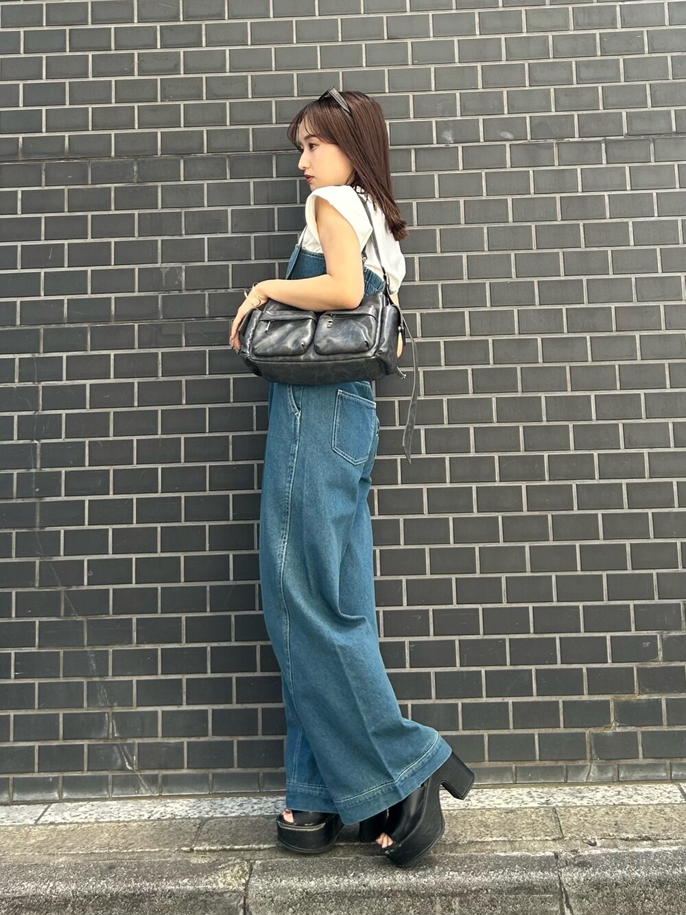 グレー系のショルダーバッグ、ブラック系のサンダル、ブルー系のつなぎ/オールインワンを着用したレディースの春コーディネートの3枚目の写真