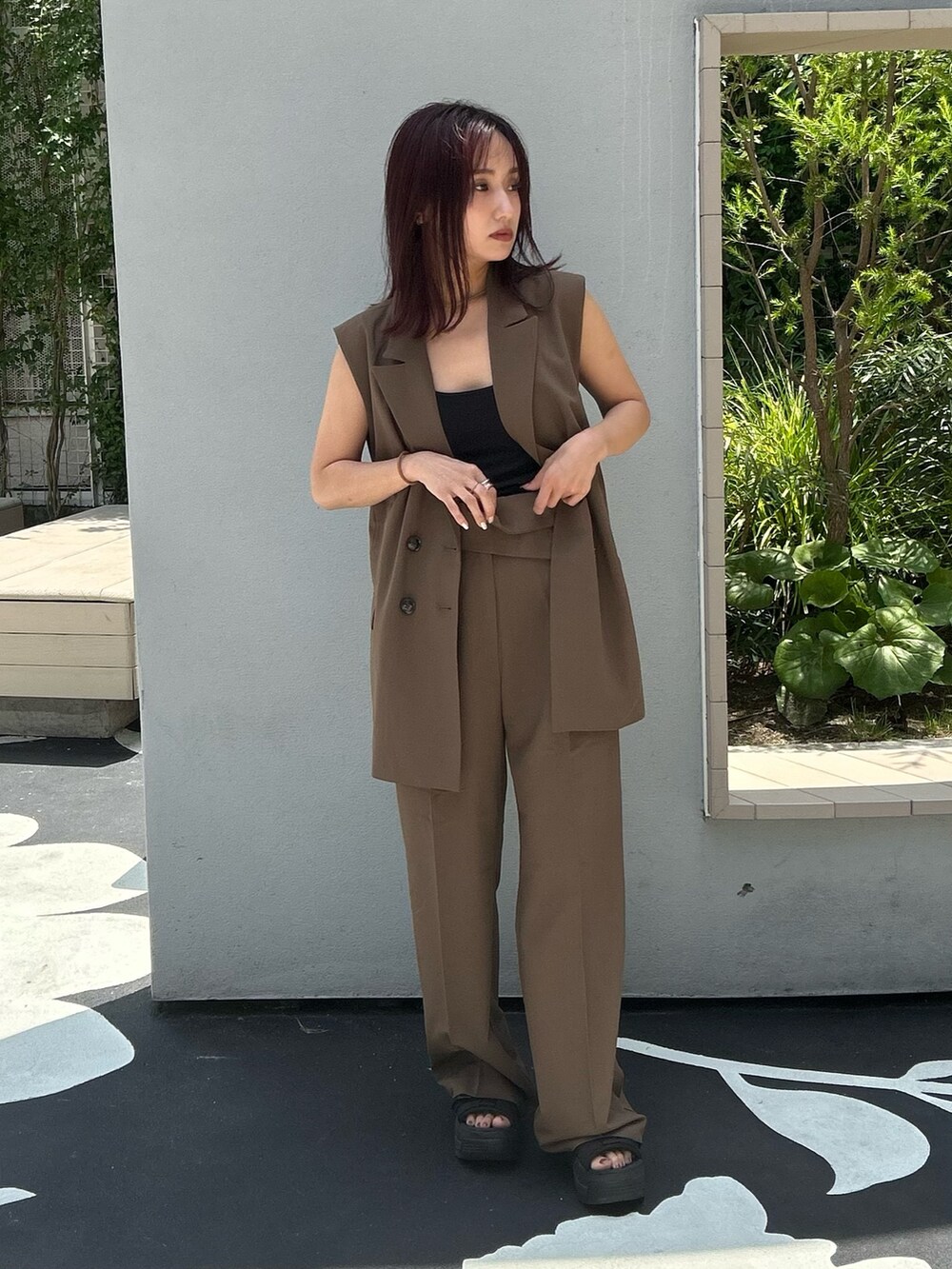 ブラック系のサンダル、ブラウン系のその他パンツ、ブラウン系のベストを着用したレディースの夏コーディネートの2枚目の写真