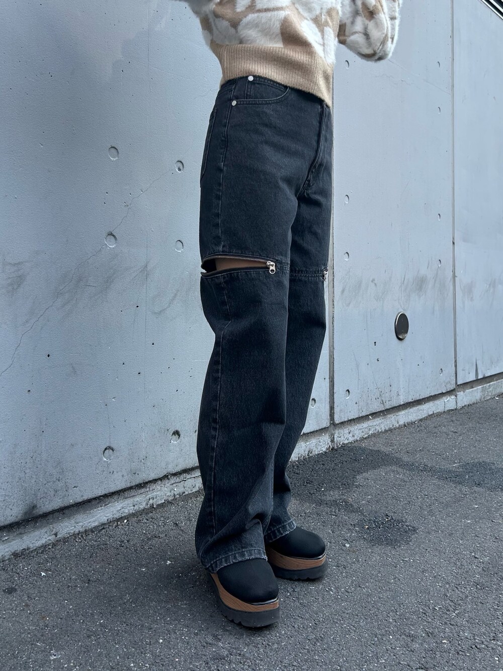 ブラック系のブーツ、ベージュ系のニット/セーター、ブラック系のデニムパンツを着用したレディースの秋コーディネートの5枚目の写真