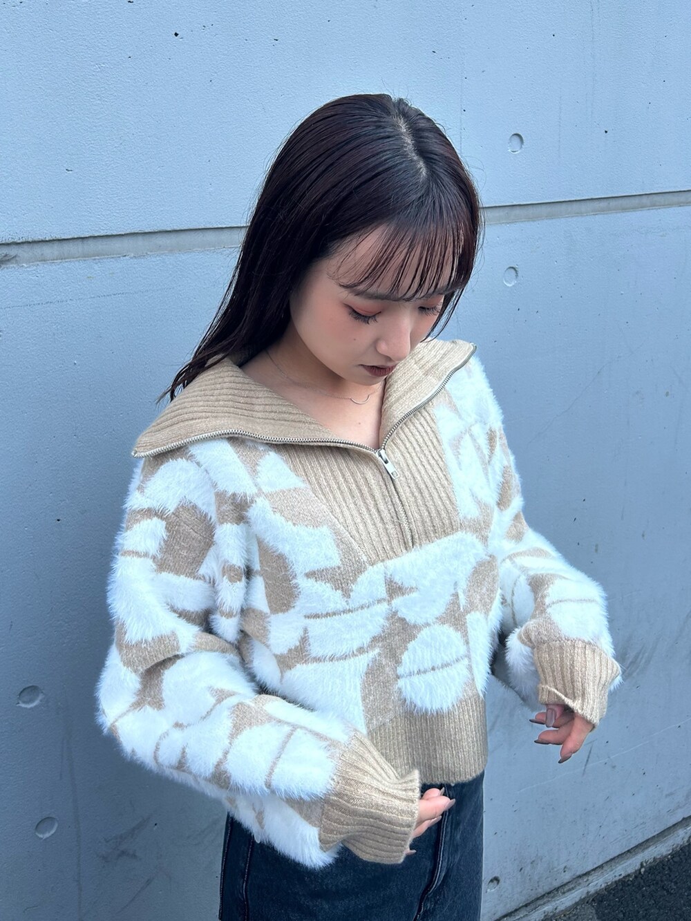 ブラック系のブーツ、ベージュ系のニット/セーター、ブラック系のデニムパンツを着用したレディースの秋コーディネートの3枚目の写真