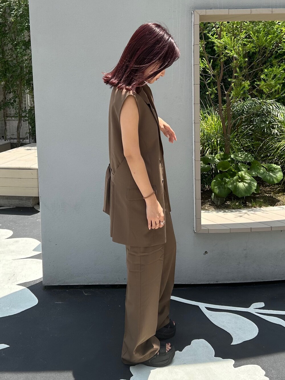 ブラック系のサンダル、ブラウン系のその他パンツ、ブラウン系のベストを着用したレディースの夏コーディネートの3枚目の写真