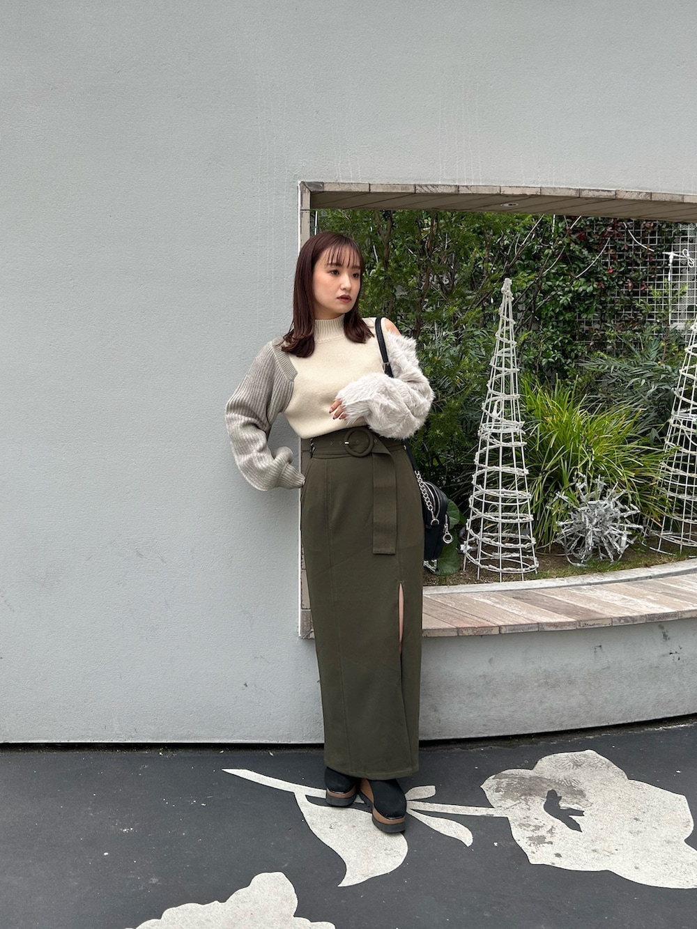 ホワイト系のニット/セーター、ブラウン系のスカート、ブラック系のショルダーバッグを着用したレディースの冬コーディネートの2枚目の写真