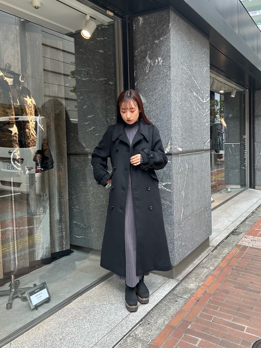 ブラック系のブーツ、グレー系のワンピース、ブラック系のチェスターコートを着用したレディースの秋コーディネートの2枚目の写真