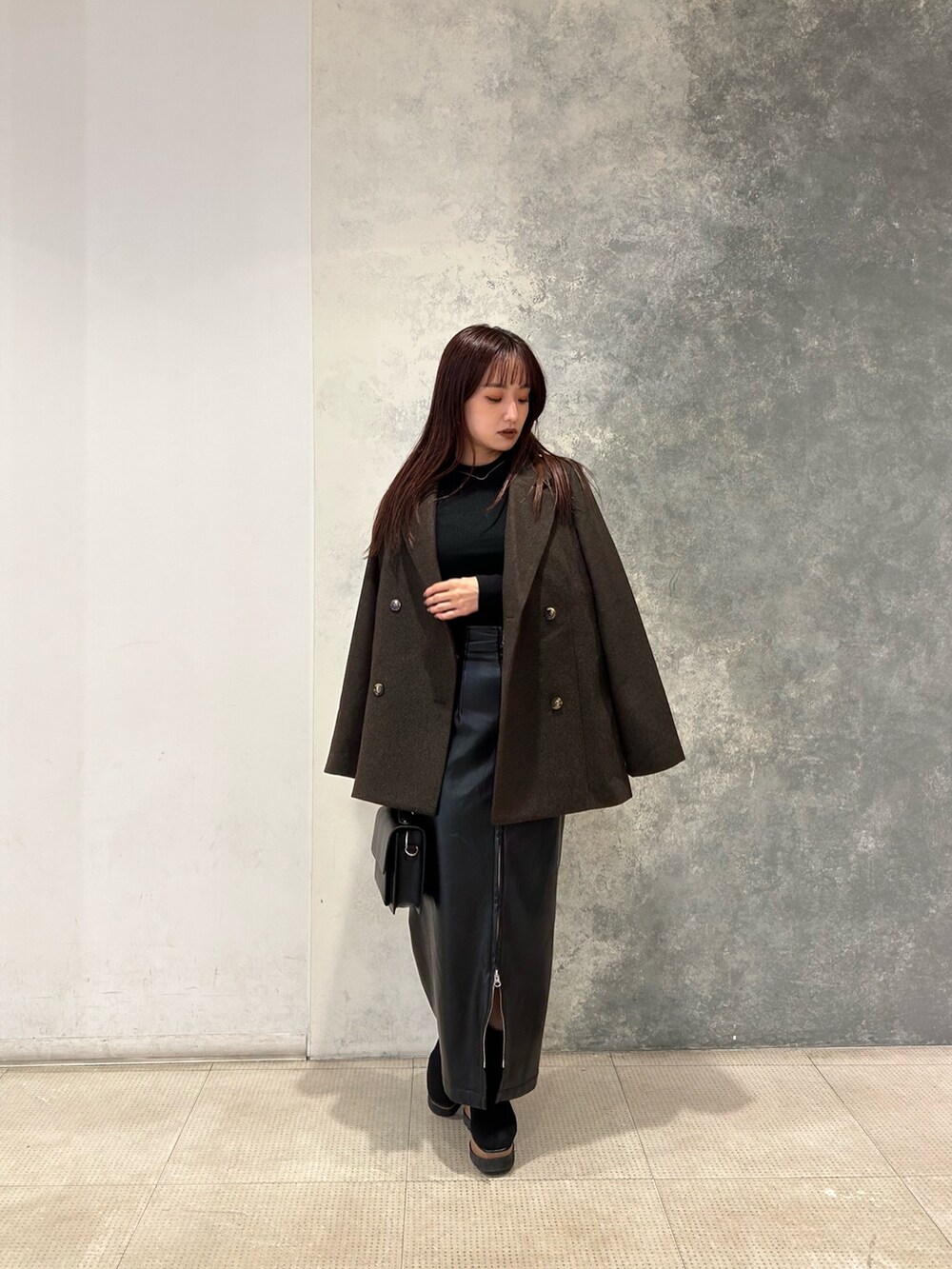 ブラウン系のテーラードジャケット、ブラック系のニット/セーター、ブラック系のブーツを着用したレディースの秋コーディネートの2枚目の写真