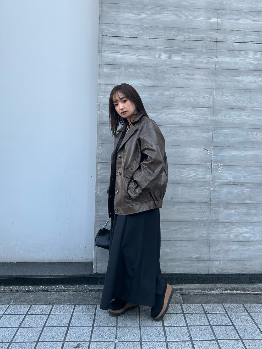 ブラック系のワンピース、ブラウン系のブルゾンを着用したレディースの冬コーディネートの2枚目の写真