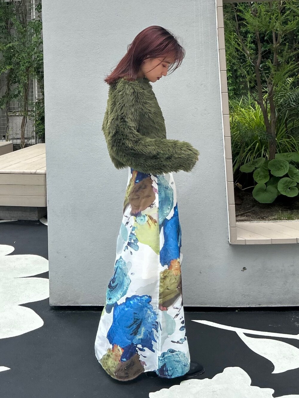 グリーン系のニット/セーター、ホワイト系のスカート、ブラック系のブーツを着用したレディースの夏コーディネートの3枚目の写真