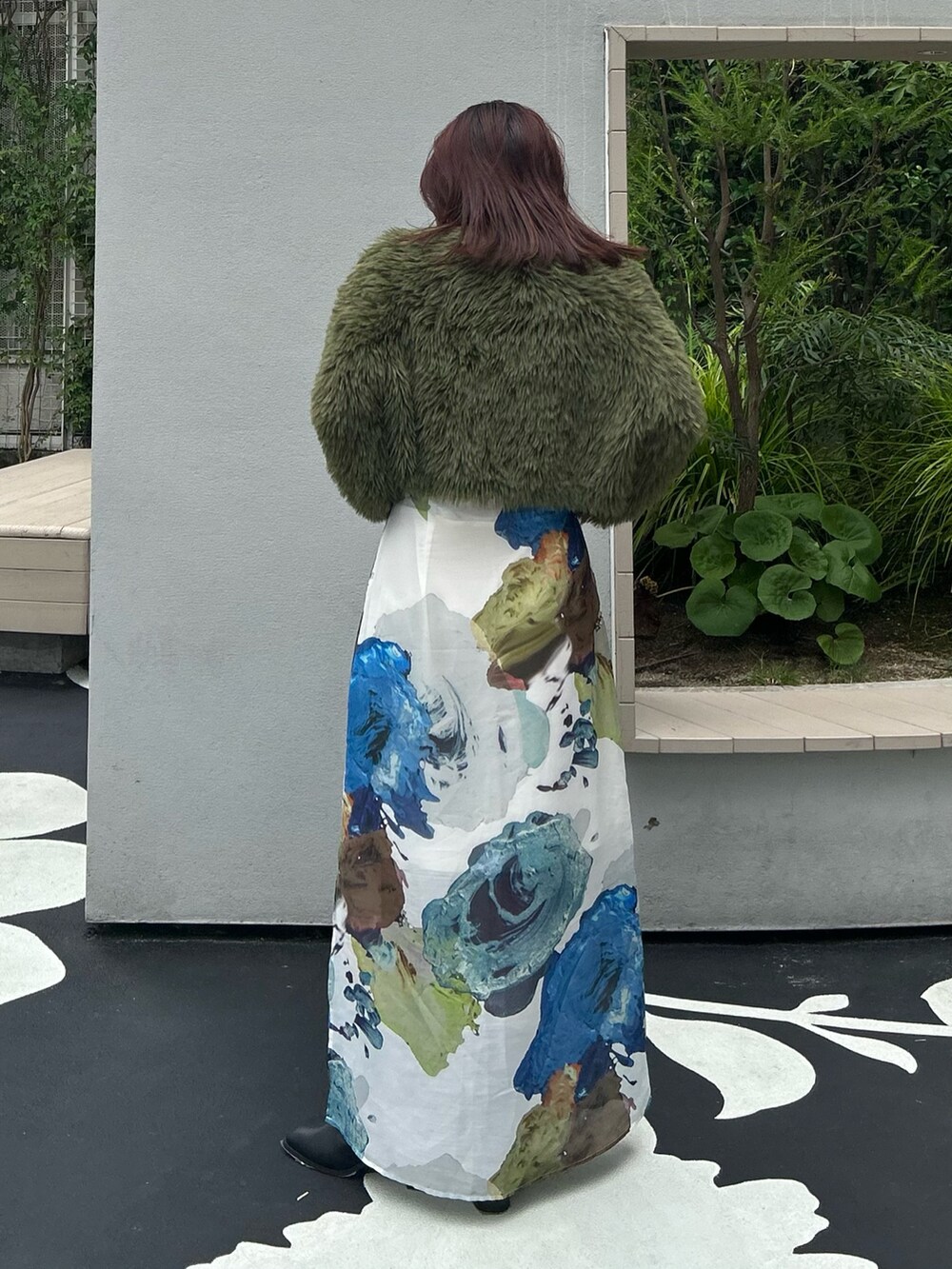 グリーン系のニット/セーター、ホワイト系のスカート、ブラック系のブーツを着用したレディースの夏コーディネートの4枚目の写真