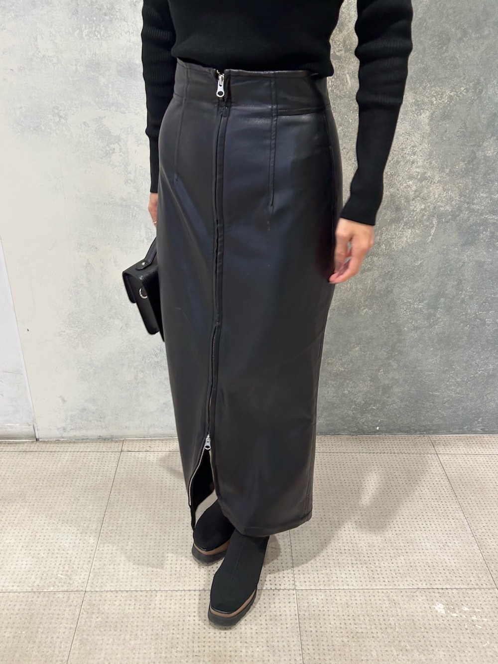 ブラウン系のテーラードジャケット、ブラック系のニット/セーター、ブラック系のブーツを着用したレディースの秋コーディネートの3枚目の写真