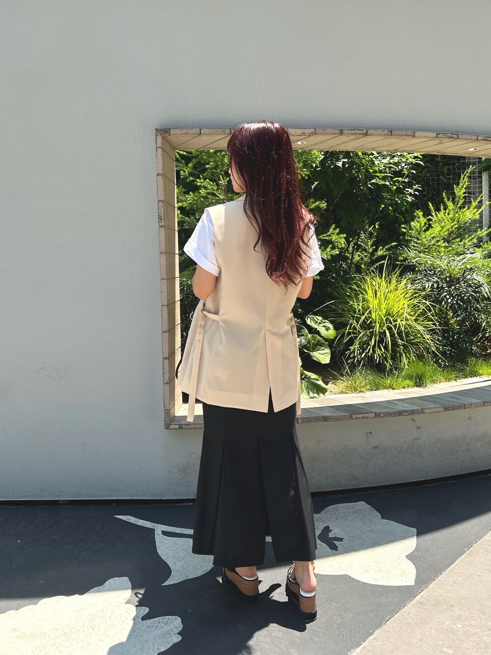 ブラック系のスカート、ホワイト系のTシャツ/カットソー、ホワイト系のベストを着用したレディースの夏コーディネートの4枚目の写真
