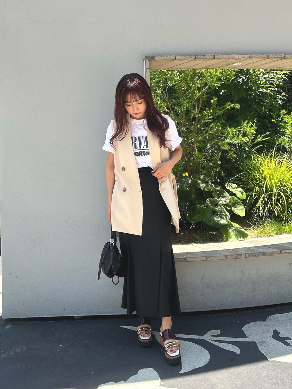 ブラック系のスカート、ホワイト系のTシャツ/カットソー、ホワイト系のベストを着用したレディースの夏コーディネートの2枚目の写真