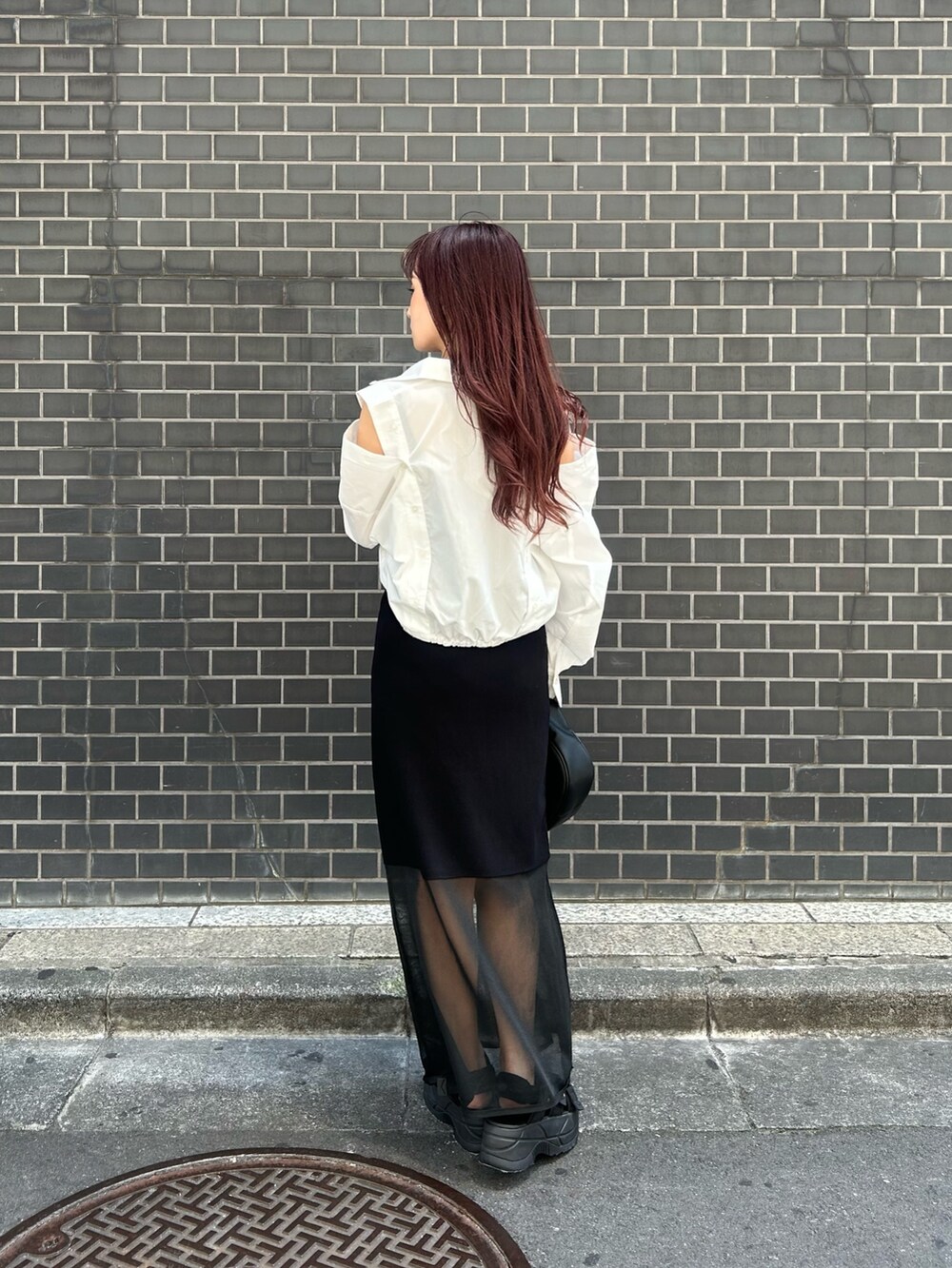 ホワイト系のシャツ/ブラウス、ブラック系のワンピース、ブラック系のサンダルを着用したレディースの夏コーディネートの2枚目の写真