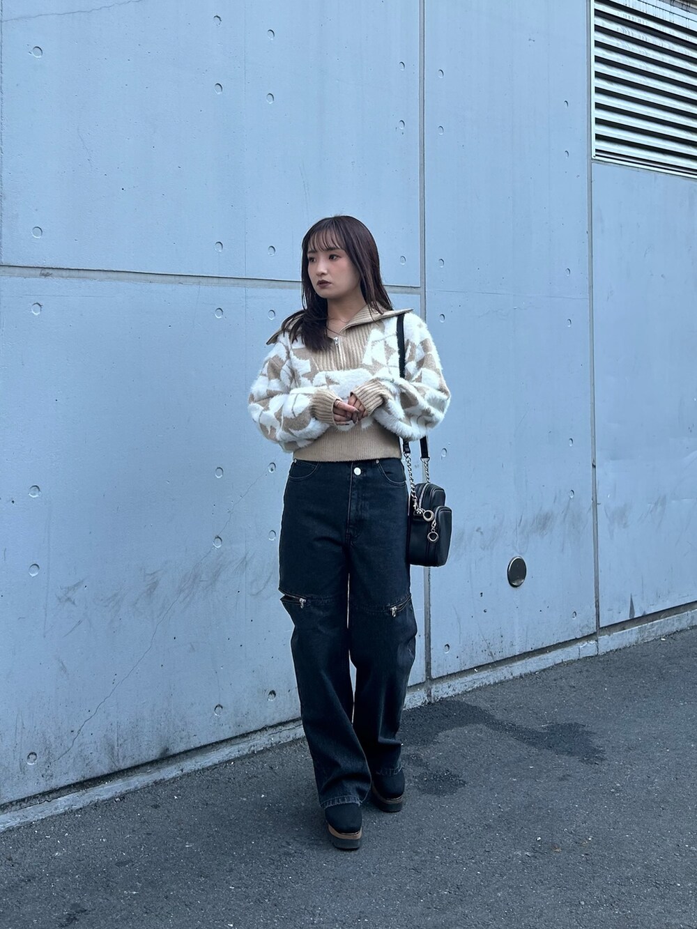 ブラック系のブーツ、ベージュ系のニット/セーター、ブラック系のデニムパンツを着用したレディースの秋コーディネートの2枚目の写真