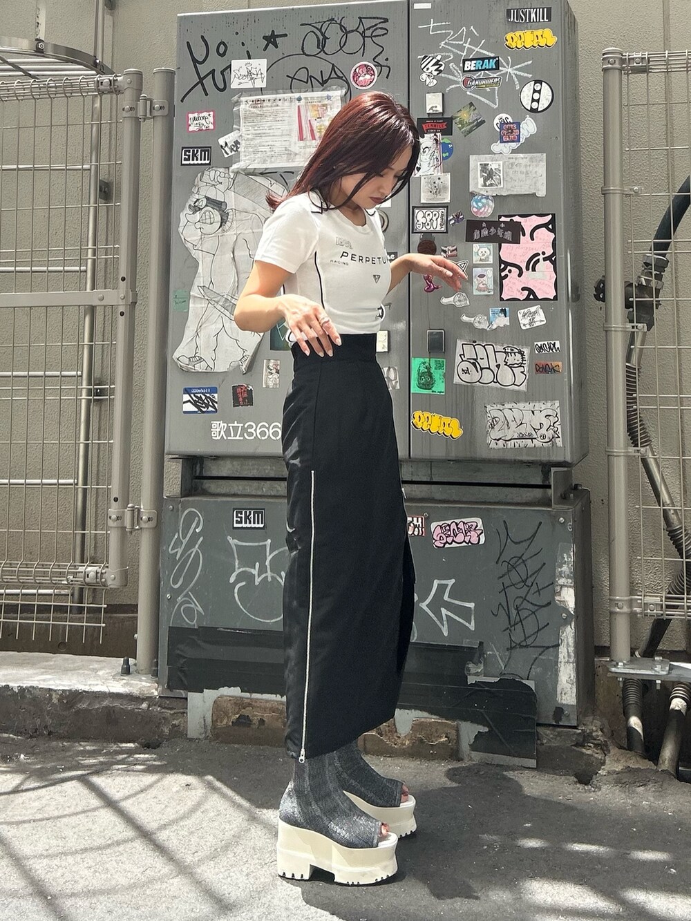 シルバー系のブーツ、ブラック系のスカート、ホワイト系のTシャツ/カットソーを着用したレディースの夏コーディネートの3枚目の写真