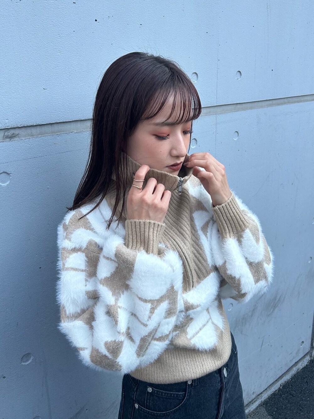 ブラック系のブーツ、ベージュ系のニット/セーター、ブラック系のデニムパンツを着用したレディースの秋コーディネートの4枚目の写真