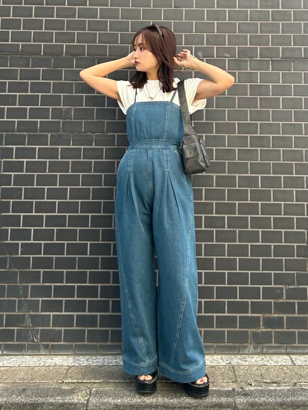グレー系のショルダーバッグ、ブラック系のサンダル、ブルー系のつなぎ/オールインワンを着用したレディースの春コーディネートの2枚目の写真