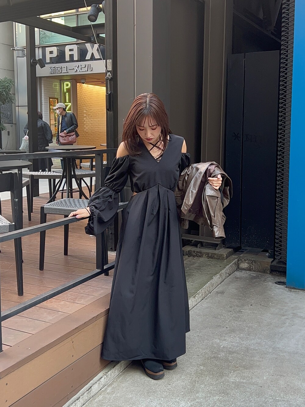 ブラック系のワンピース、ブラウン系のブルゾンを着用したレディースの冬コーディネートの3枚目の写真