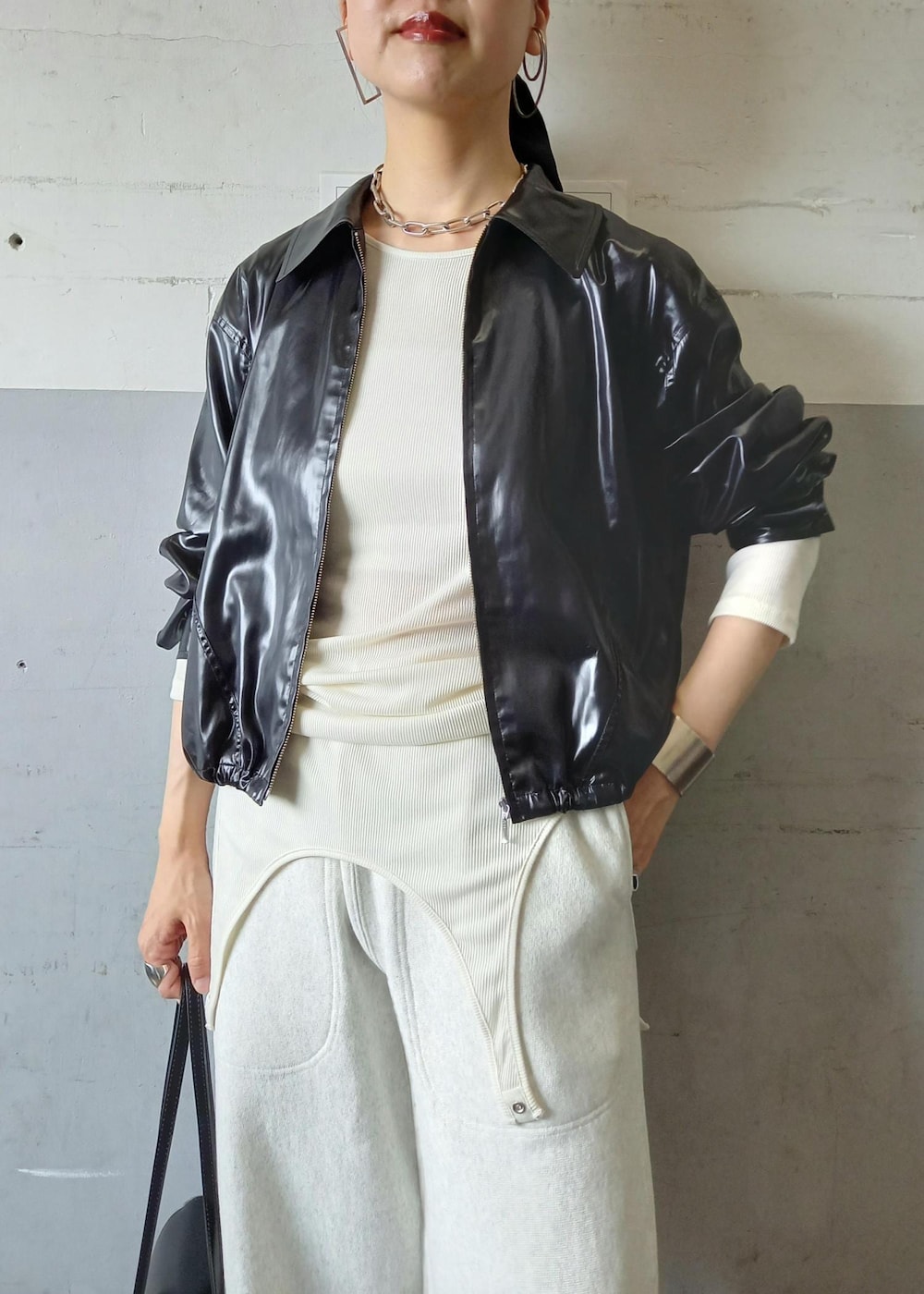 ブラック系のブルゾン、ホワイト系のTシャツ/カットソー、ブラック系のショルダーバッグを着用したレディースの秋コーディネートの9枚目の写真