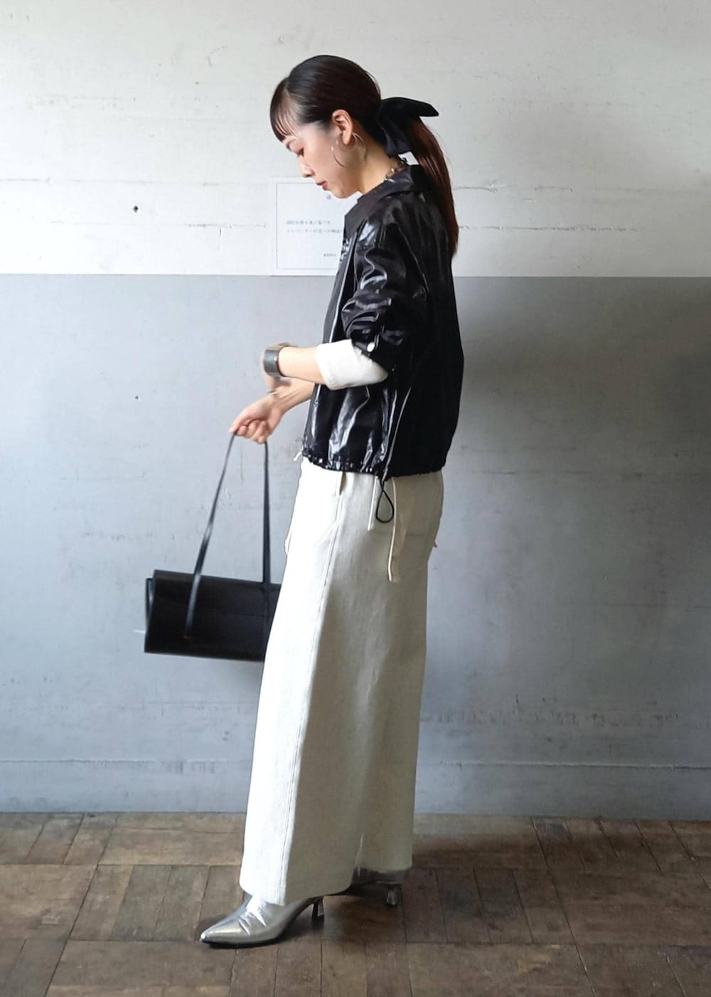 ブラック系のブルゾン、ホワイト系のTシャツ/カットソー、ブラック系のショルダーバッグを着用したレディースの秋コーディネートの4枚目の写真