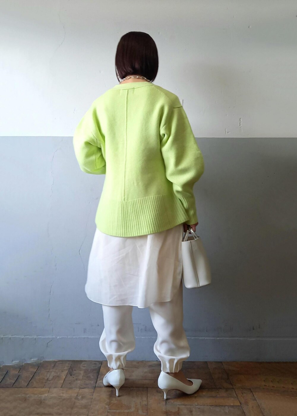 ホワイト系のショルダーバッグ、グリーン系のカーディガン/ボレロ、ホワイト系のパンプスを着用したレディースの秋コーディネートの5枚目の写真