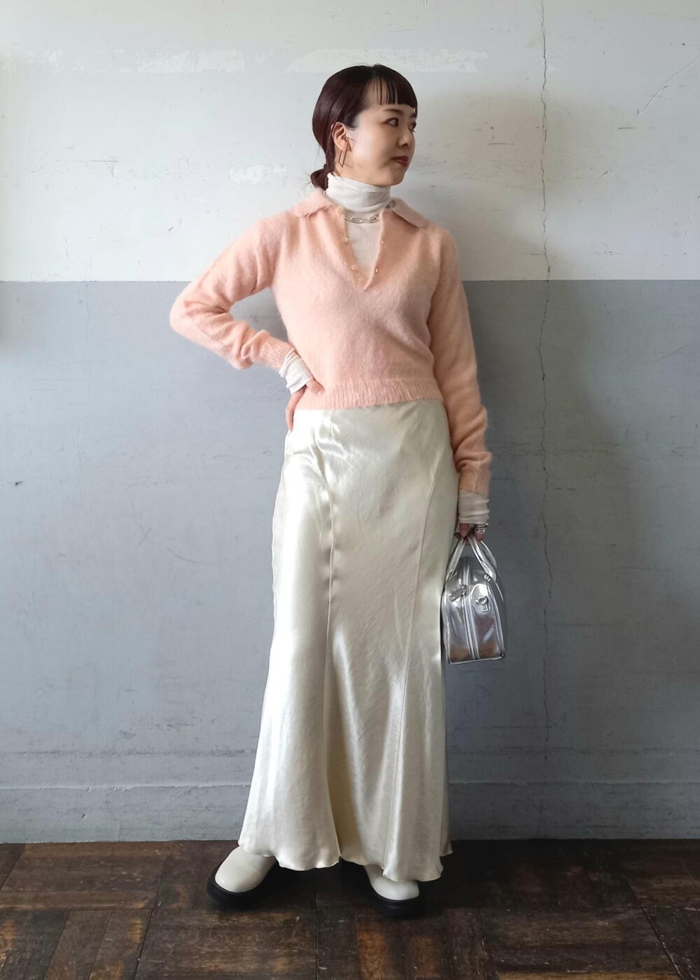 ホワイト系のブーツ、ベージュ系のスカート、ホワイト系のニット/セーターを着用したレディースの冬コーディネートの2枚目の写真