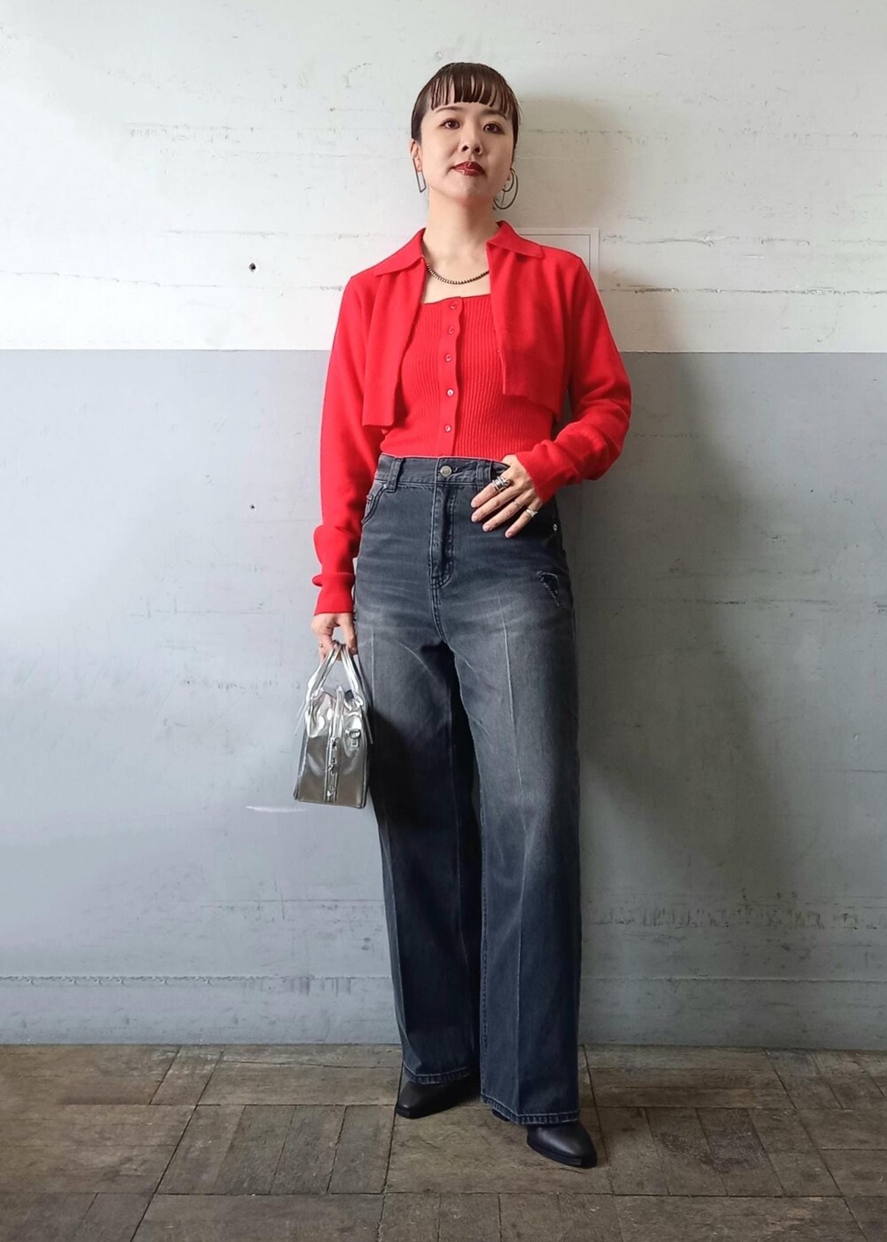 レッド系のカーディガン/ボレロ、ブラック系のデニムパンツ、シルバー系のショルダーバッグを着用したレディースの秋コーディネートの4枚目の写真