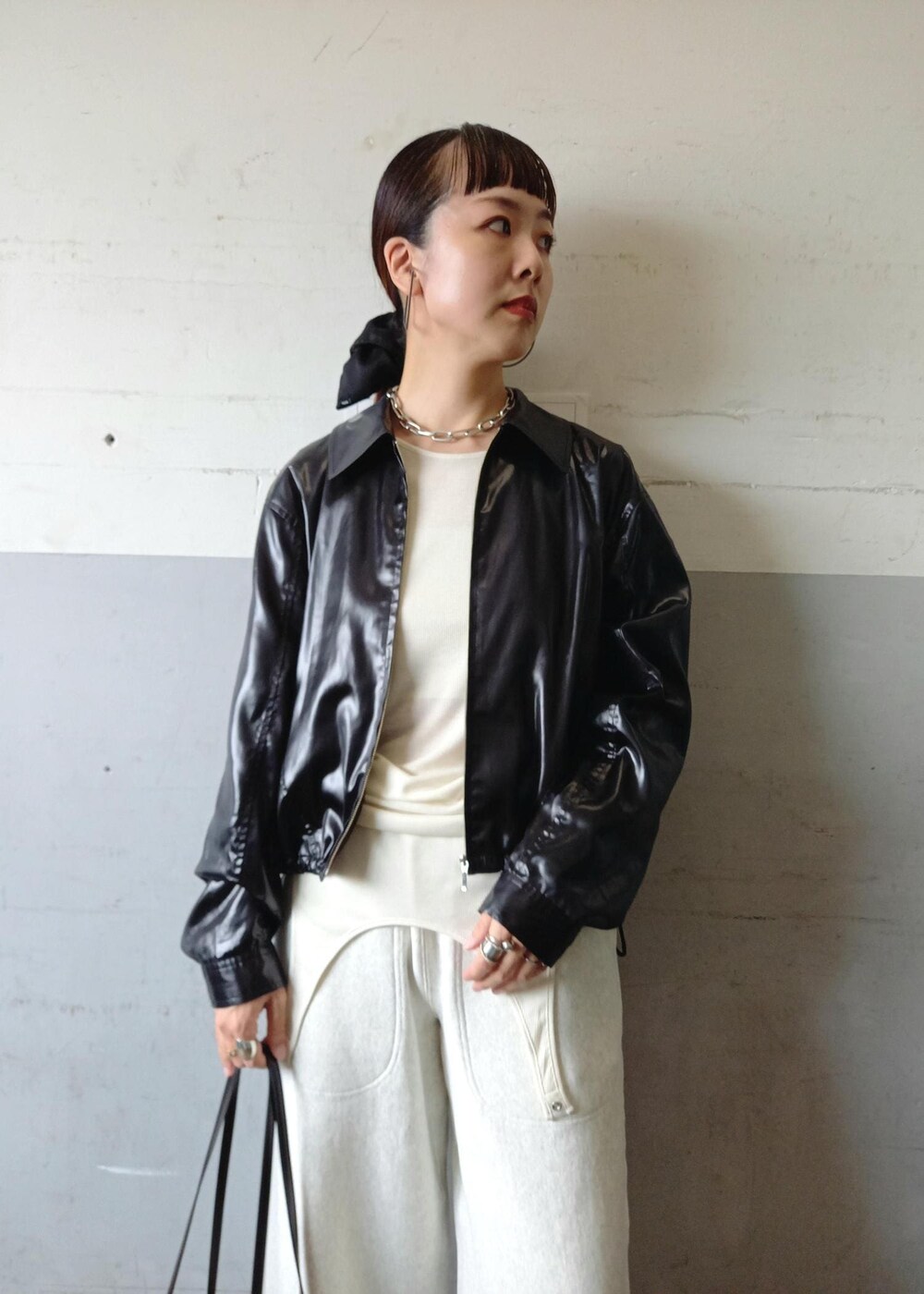 ブラック系のブルゾン、ホワイト系のTシャツ/カットソー、ブラック系のショルダーバッグを着用したレディースの秋コーディネートの10枚目の写真