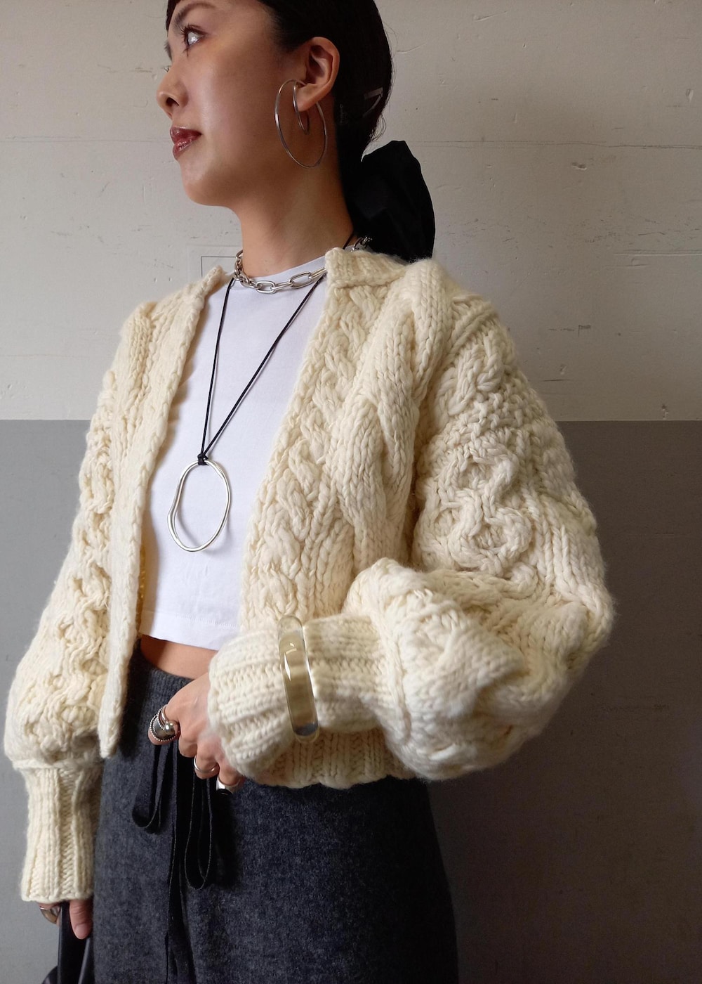 ブラック系のハンドバッグ、ホワイト系のカーディガン/ボレロ、グレー系のその他パンツを着用したレディースの秋コーディネートの10枚目の写真