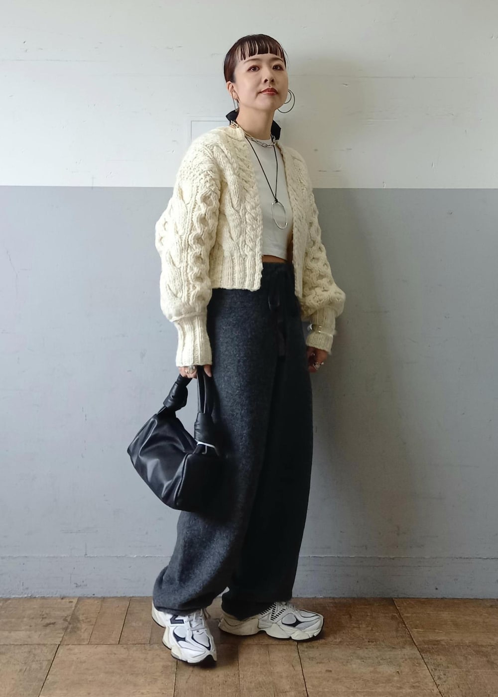 ブラック系のハンドバッグ、ホワイト系のカーディガン/ボレロ、グレー系のその他パンツを着用したレディースの秋コーディネートの4枚目の写真