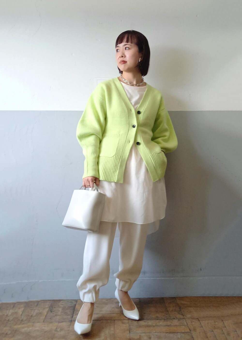 ホワイト系のショルダーバッグ、グリーン系のカーディガン/ボレロ、ホワイト系のパンプスを着用したレディースの秋コーディネートの6枚目の写真