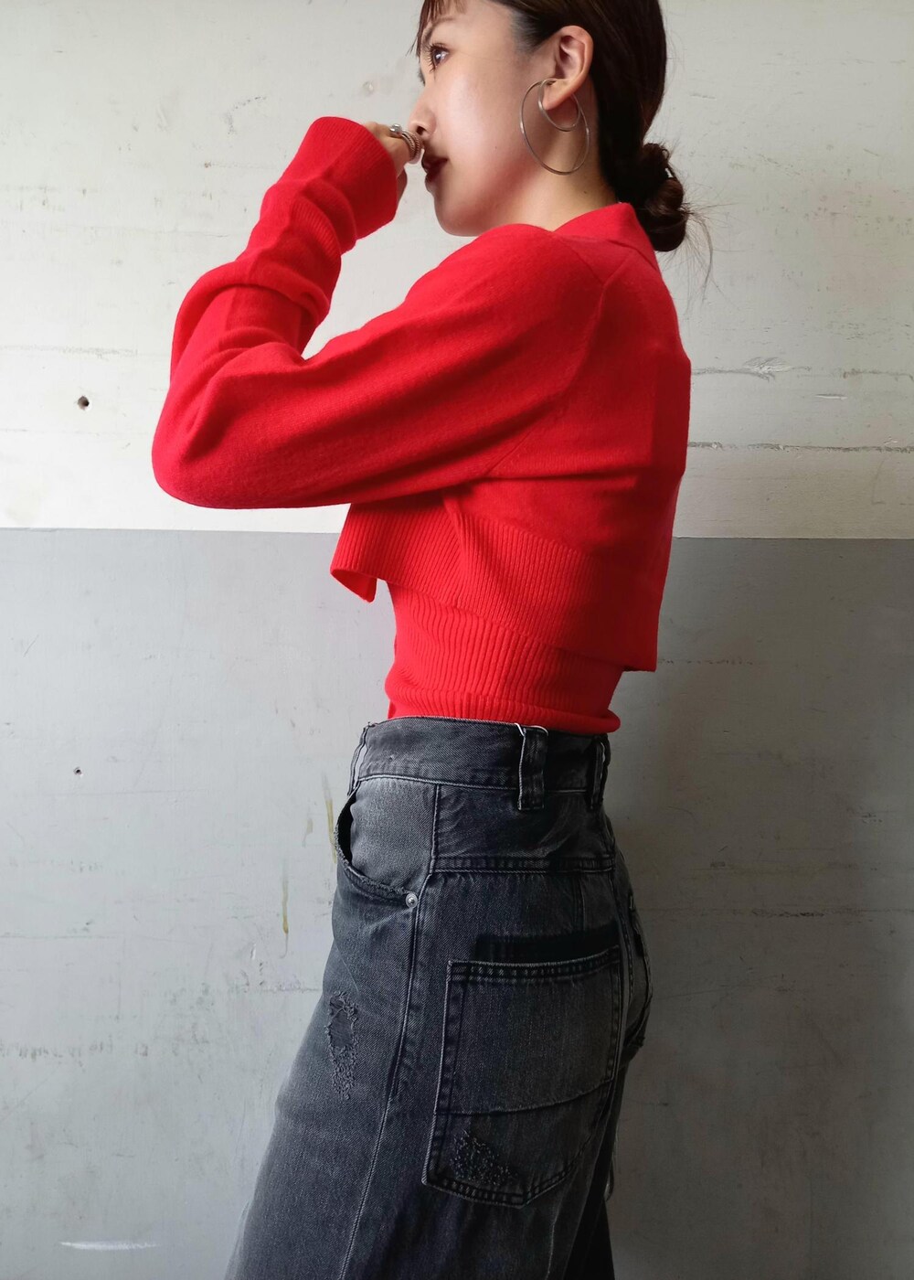 レッド系のカーディガン/ボレロ、ブラック系のデニムパンツ、シルバー系のショルダーバッグを着用したレディースの秋コーディネートの9枚目の写真