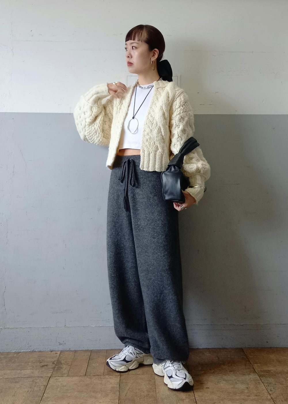 ブラック系のハンドバッグ、ホワイト系のカーディガン/ボレロ、グレー系のその他パンツを着用したレディースの秋コーディネートの3枚目の写真