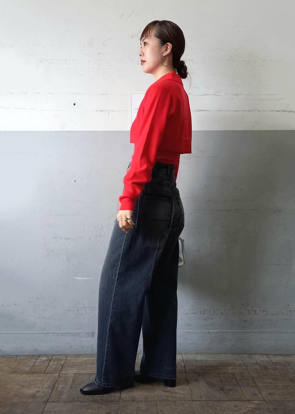 レッド系のカーディガン/ボレロ、ブラック系のデニムパンツ、シルバー系のショルダーバッグを着用したレディースの秋コーディネートの6枚目の写真