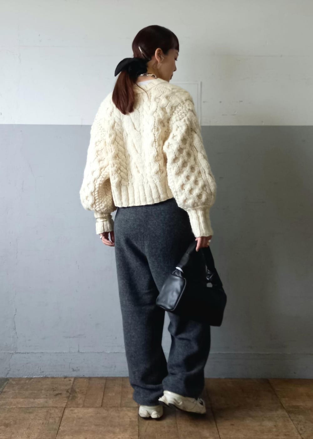 ブラック系のハンドバッグ、ホワイト系のカーディガン/ボレロ、グレー系のその他パンツを着用したレディースの秋コーディネートの9枚目の写真