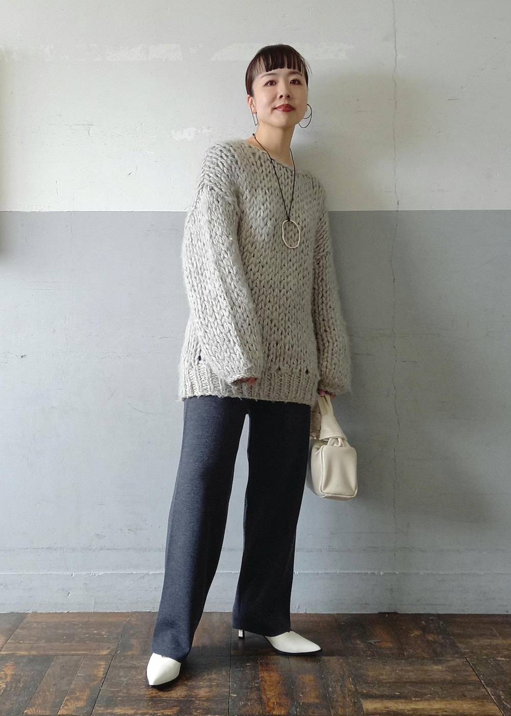 ホワイト系のパンプス、グレー系のスウェット、グレー系のその他パンツを着用したレディースの冬コーディネートの7枚目の写真