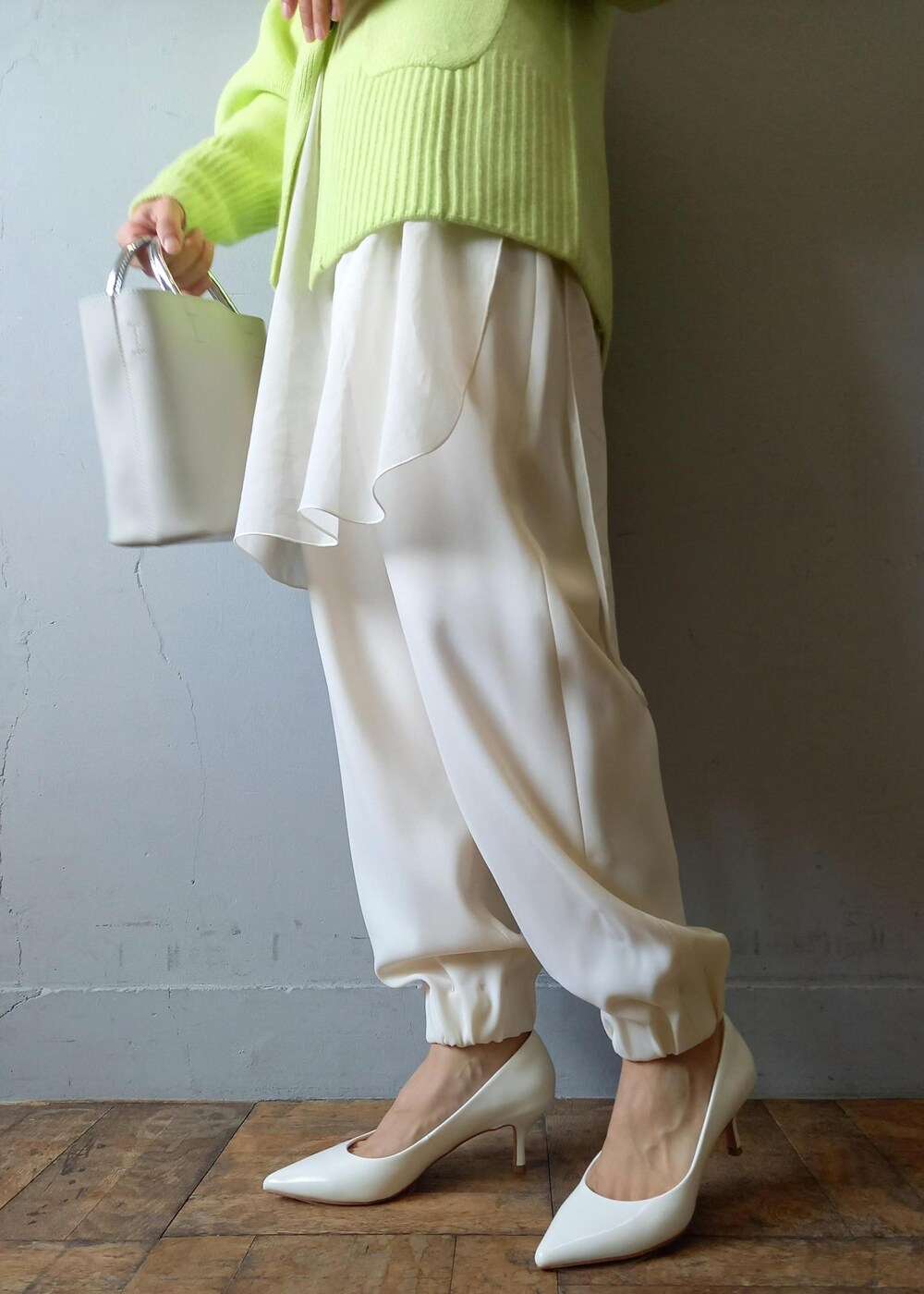 ホワイト系のショルダーバッグ、グリーン系のカーディガン/ボレロ、ホワイト系のパンプスを着用したレディースの秋コーディネートの10枚目の写真