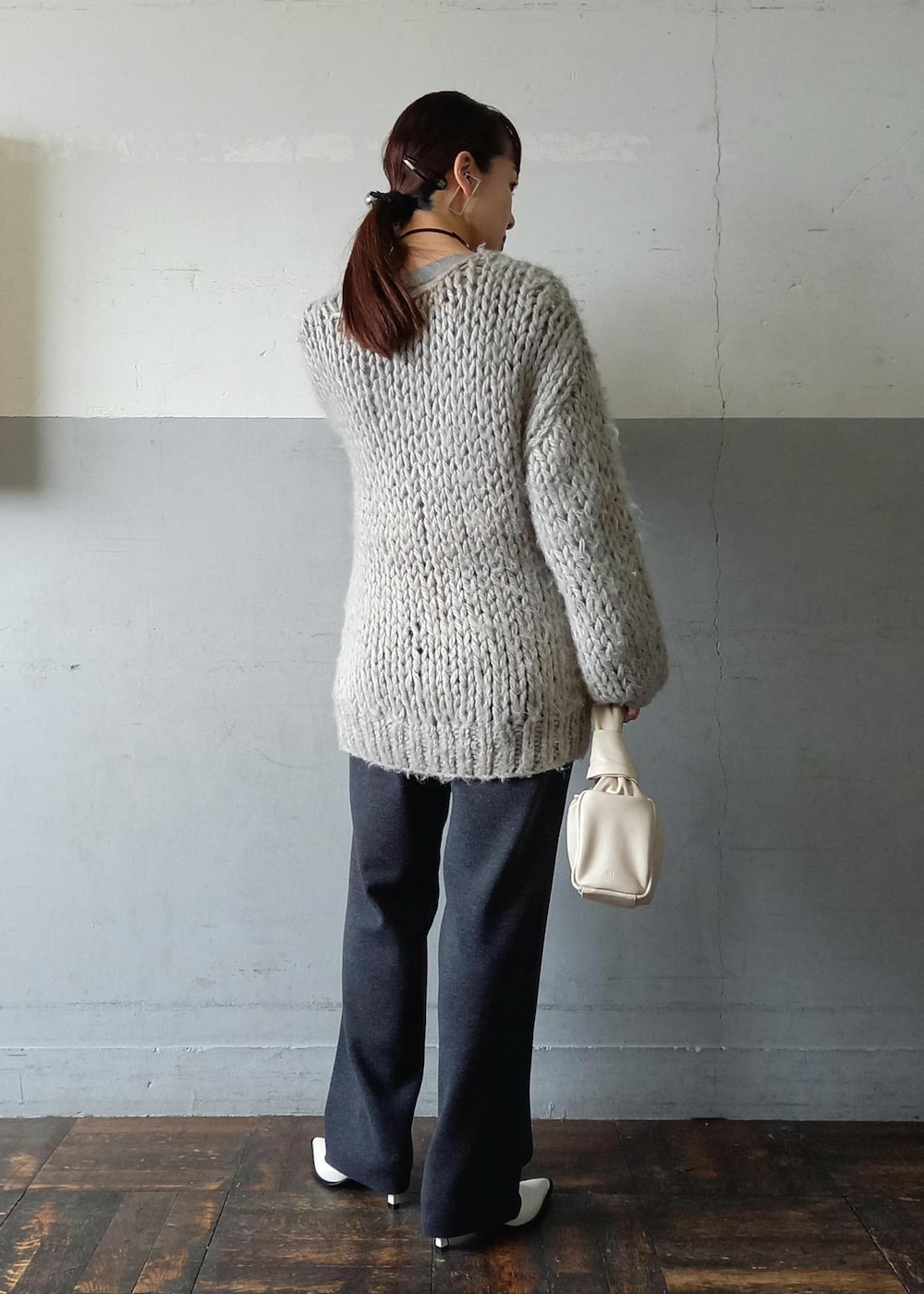 ホワイト系のパンプス、グレー系のスウェット、グレー系のその他パンツを着用したレディースの冬コーディネートの6枚目の写真