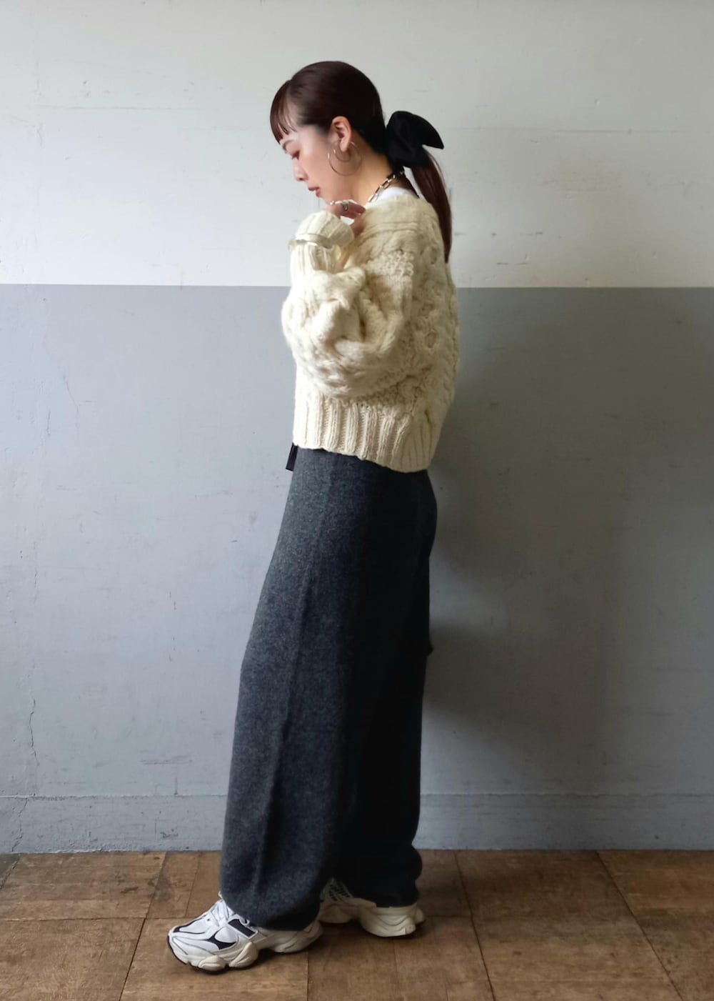 ブラック系のハンドバッグ、ホワイト系のカーディガン/ボレロ、グレー系のその他パンツを着用したレディースの秋コーディネートの7枚目の写真