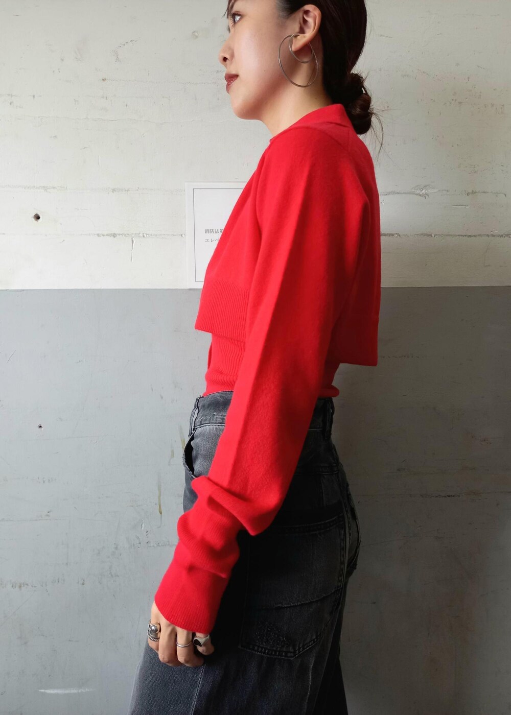 レッド系のカーディガン/ボレロ、ブラック系のデニムパンツ、シルバー系のショルダーバッグを着用したレディースの秋コーディネートの10枚目の写真