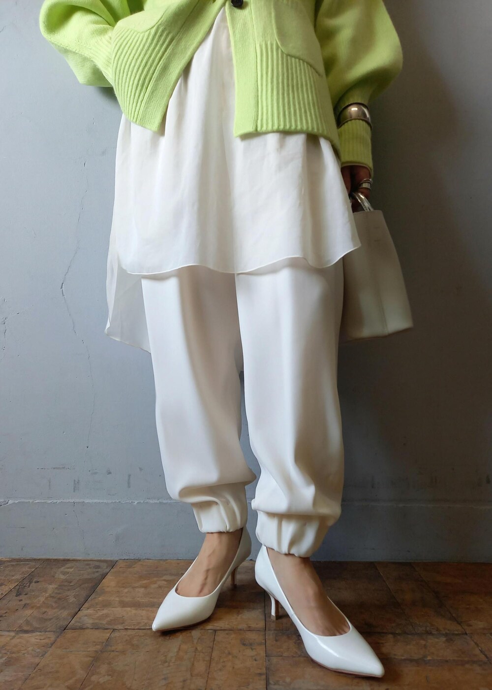 ホワイト系のショルダーバッグ、グリーン系のカーディガン/ボレロ、ホワイト系のパンプスを着用したレディースの秋コーディネートの9枚目の写真