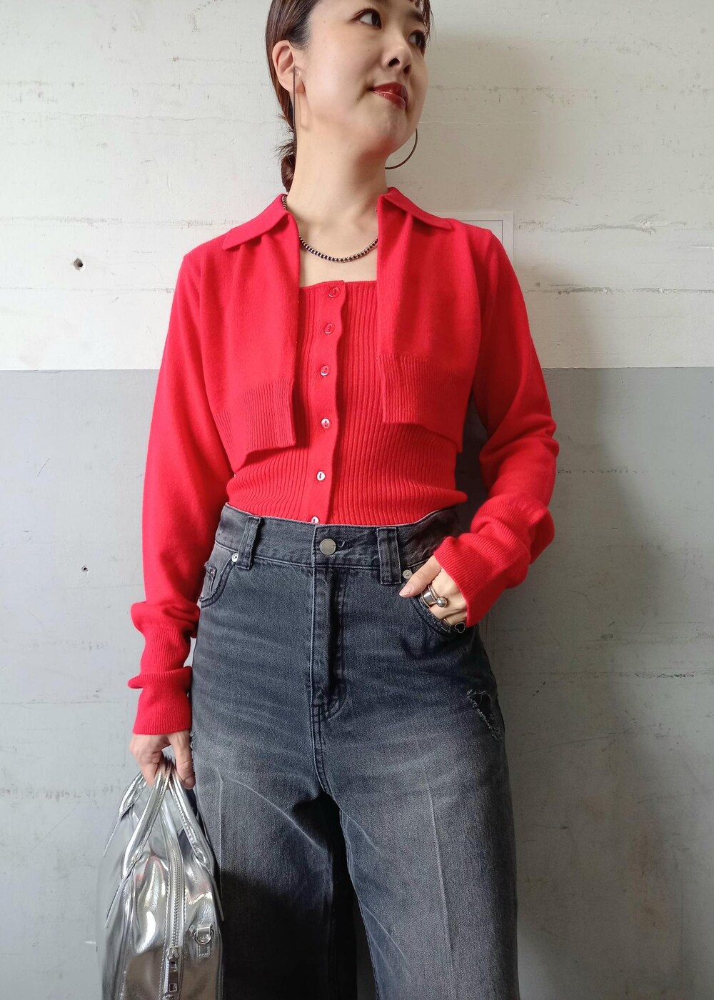 レッド系のカーディガン/ボレロ、ブラック系のデニムパンツ、シルバー系のショルダーバッグを着用したレディースの秋コーディネートの8枚目の写真