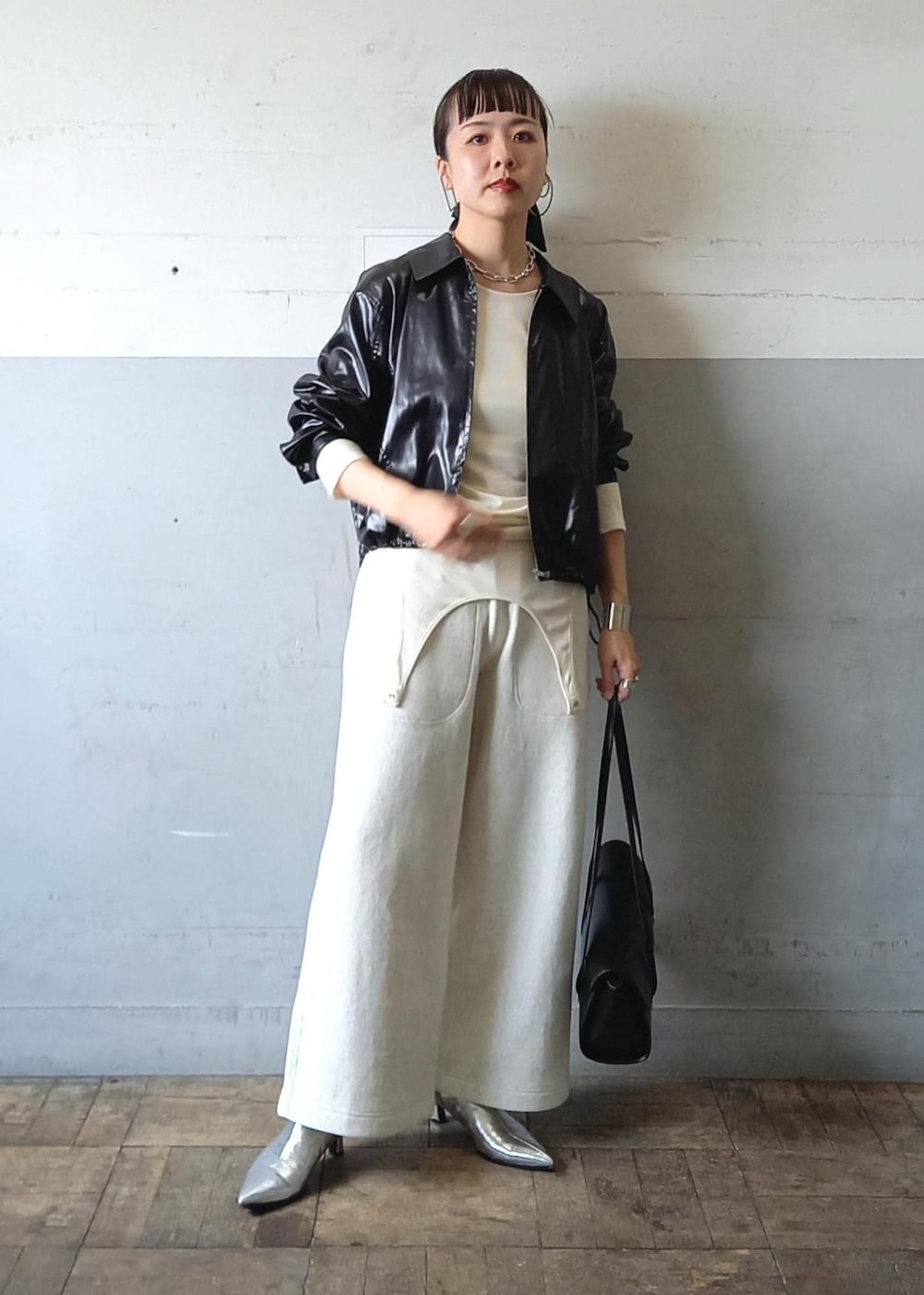 ブラック系のブルゾン、ホワイト系のTシャツ/カットソー、ブラック系のショルダーバッグを着用したレディースの秋コーディネートの3枚目の写真