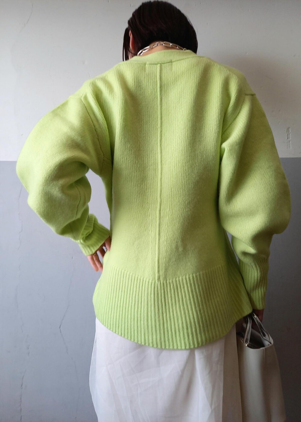 ホワイト系のショルダーバッグ、グリーン系のカーディガン/ボレロ、ホワイト系のパンプスを着用したレディースの秋コーディネートの8枚目の写真